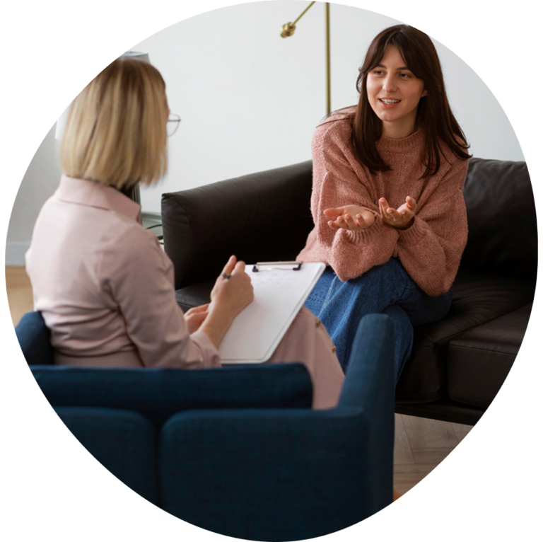 Therapist taking notes while talking with a young woman